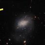 Hubble Space Telescope Captures A Surprise Visitor Streaking Across A Distant Galaxy
